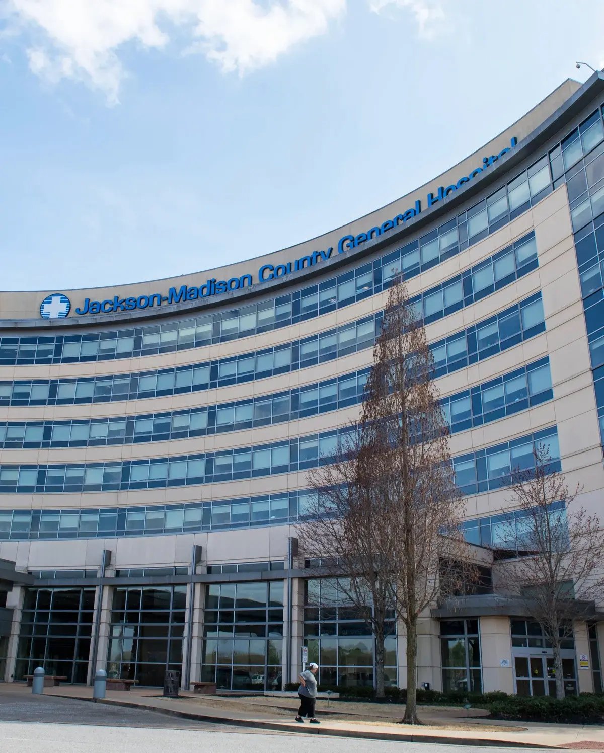 The curved exterior and main entrance of Jackson-Madison County General Hospital on a sunny day