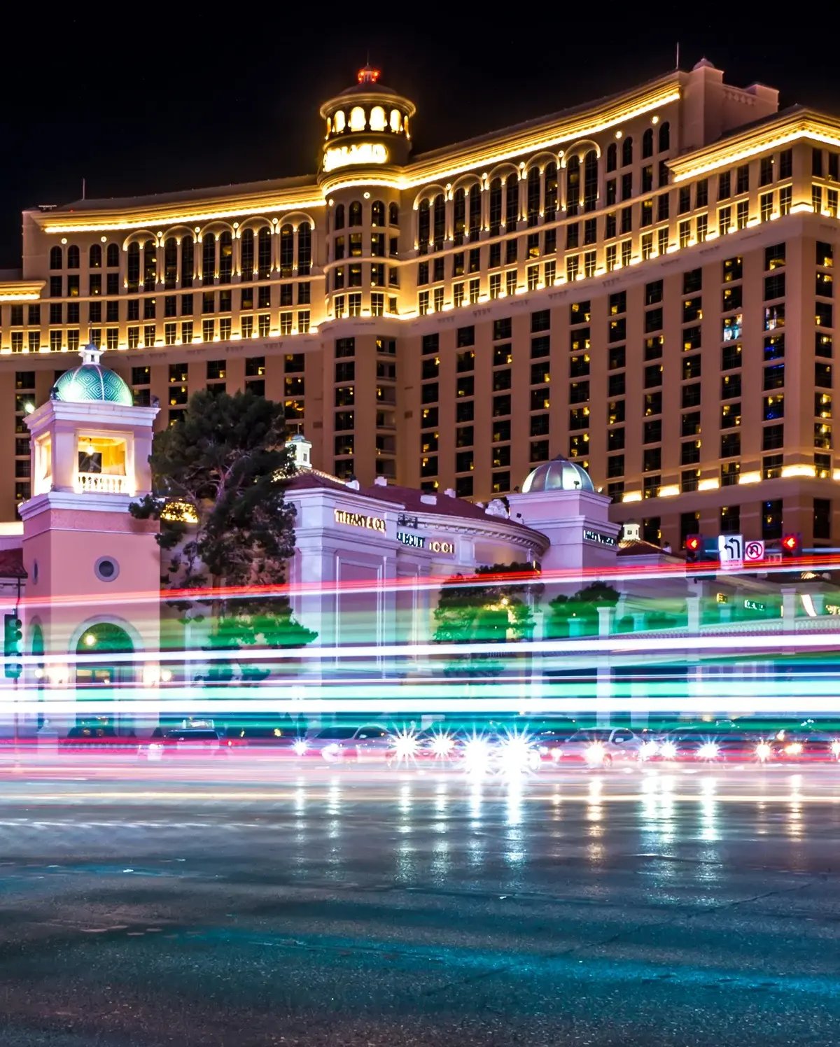 A Las Vegas casino hotel at night with long exposure streaks of light from moving traffic A Las Vegas casino hotel at night with long exposure streaks of light from moving traffic